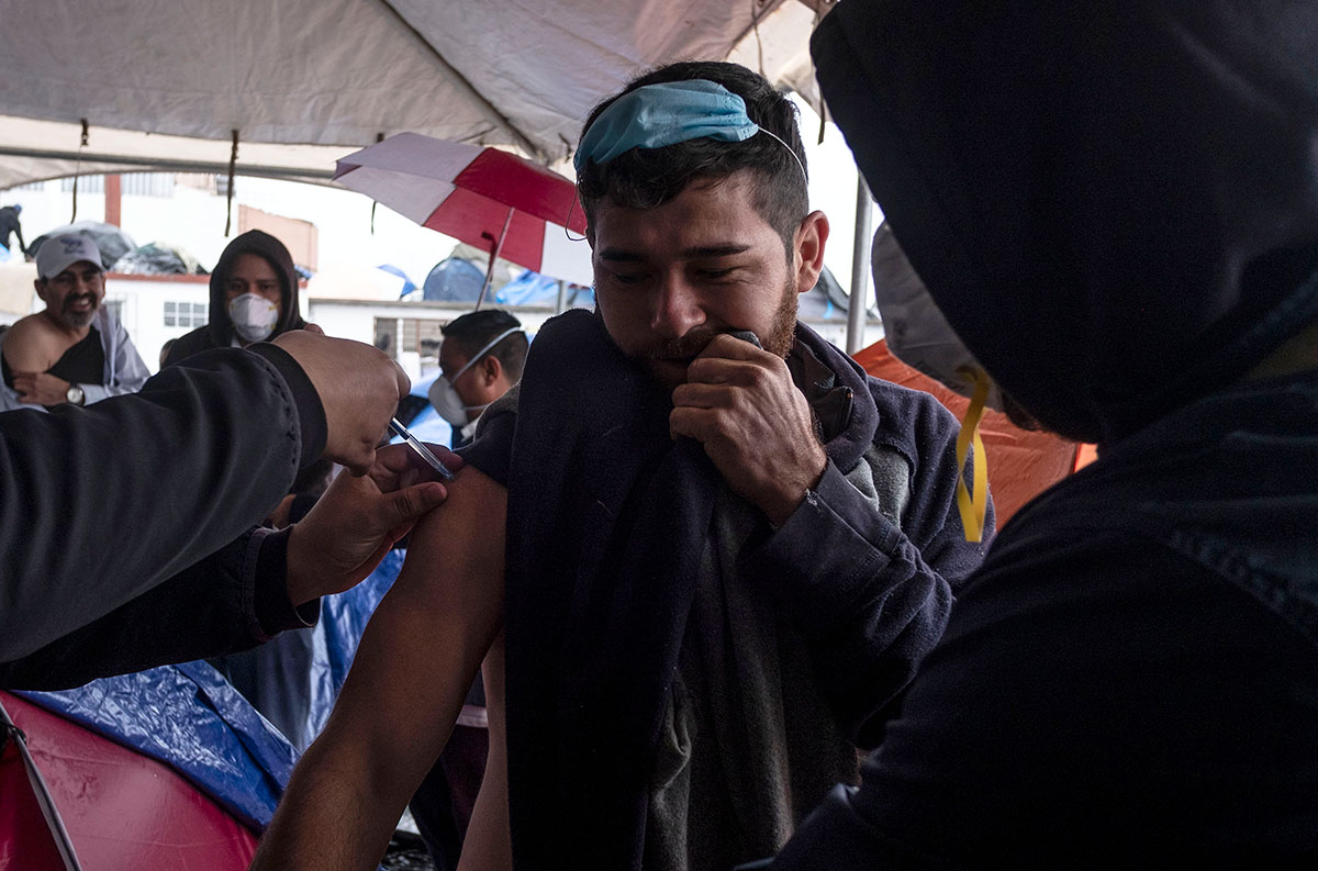 Migrantes son vacunados contra la COVID-19 en Tijuana México.