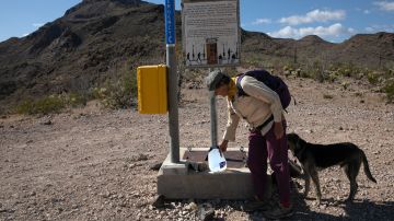 Un voluntario del No More Deaths coloca una botella de agua cerca de una baliza de rescate en el desierto, en Arizona.