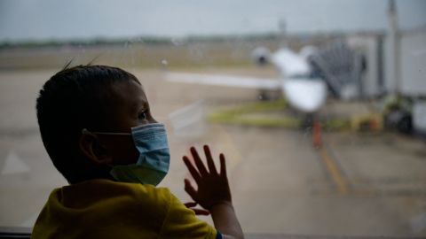 Un niño migrante espera  con su padre )que no se ve en la foto) en el aeropuerto de McAllen después de ser liberado.