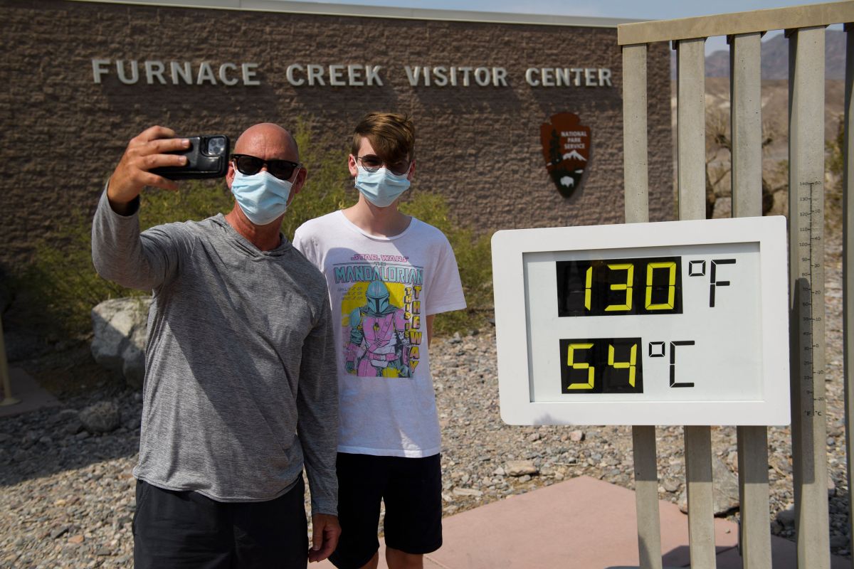 Turistas posan en Death Valley, California, donde un termómetro indica 130 grados Fahrenheit (54 centígrados).