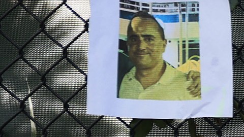 La gente mira fotografías de algunos de los desaparecidos de Champlain Towers South de 12 pisos, parcialmente derrumbado.