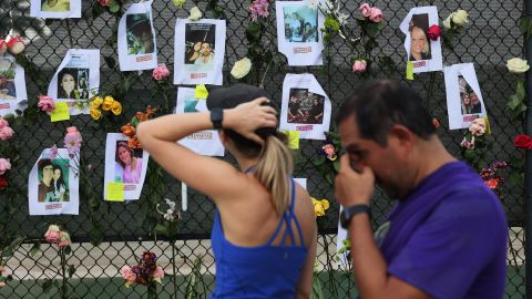 La gente mira fotografías de algunos de los desaparecidos de Champlain Towers South de 12 pisos, parcialmente derrumbado.