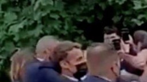 El momento justo después de que el hombre de verde y pelo largo abofeteara a Macron.