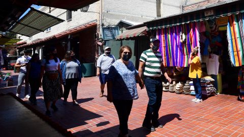 Personas caminando con mascarilla