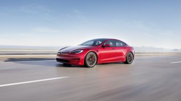 Foto del Model S Plaid de Tesla de color rojo corriendo por la carretera