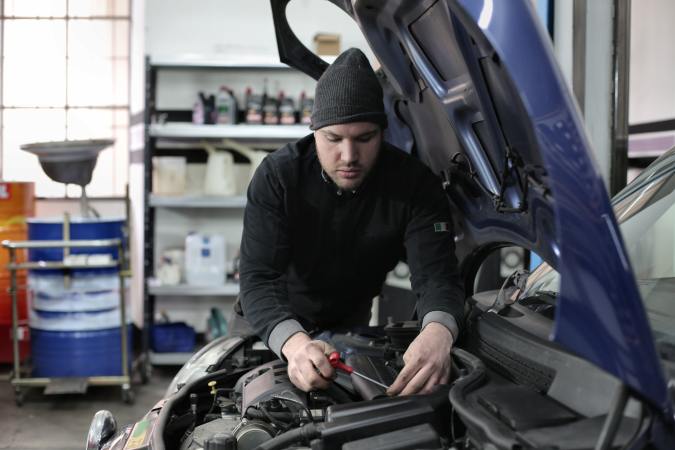 Foto de un mecánico revisando el motor de un auto