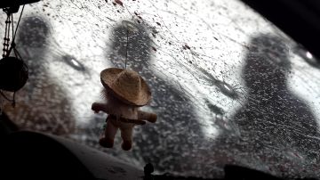 Forensics personnel and investigators inspect the bullet-riddled windshield of a car followimng an attack by gunmen that killed two policemen on a street in Culiacan, Sinaloa state, July 12, 2011.  Mexico has been gripped by drug-related violence that has killed some 37,000 people since 2006, when the government launched a military crackdown on the cartels.   AFP PHOTO / Yuri CORTEZ (Photo credit should read YURI CORTEZ/AFP via Getty Images)