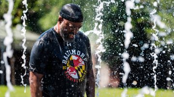 Un hombre se refresca en una fuente en Baltimore, Maryland.