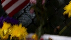 La gente visita el monumento con fotos de algunos de los desaparecidos de Champlain Towers South.