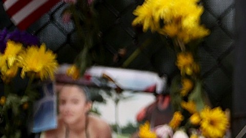 La gente visita el monumento con fotos de algunos de los desaparecidos de Champlain Towers South.
