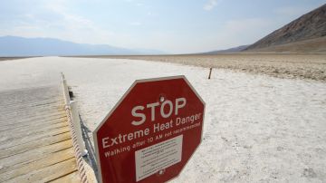 Carteles advierten del peligro de calor extremo  dentro del Parque Nacional Valle de la Muerte, en California.