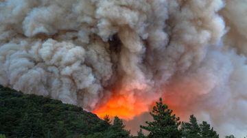 CHERRY VALLEY, CA - AUGUST 01: Flames and heavy smoke approach on a western front of the Apple Fire, consuming brush and forest at a high rate of speed during an excessive heat warning on August 1, 2020 in Cherry Valley, California. The fire began shortly before 5 p.m. the previous evening, threatening a large number of homes overnight and forcing thousands to flee before exploding to 12,000 acres this afternoon, mostly climbing the steep wilderness slopes of the San Bernardino Mountains.  (Photo by David McNew/Getty Images)