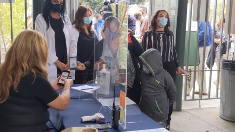 Sonia Cano y su hijo Daniel hacen una demostración de los pasos a seguir al entrar a la escuela. (Jacqueline García/La Opinión)