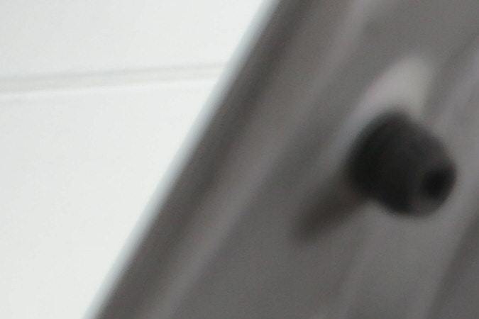 Foto de un hombre inspeccionando un auto con una linterna