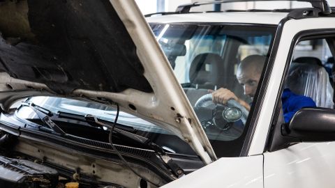 Foto de una persona tratando de encender un auto