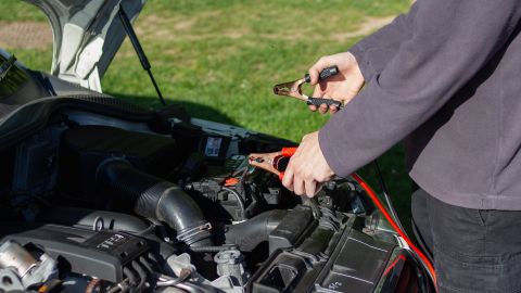 Foto de una persona manipulando la batería de un auto