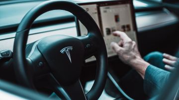 Foto de una persona operando un auto de Tesla
