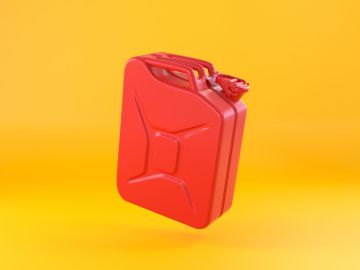 Foto de un recipiente rojo para almacenar gasolina sobre fondo amarillo