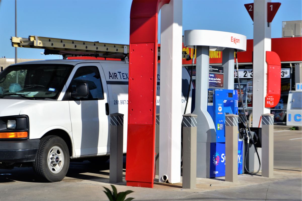 Foto de un auto comercial cargando gasolina en una estación de servicio