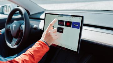 Foto de una persona operando la pantalla de un auto de Tesla