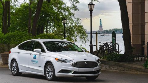 Foto de un vehículo autónomo de Mobileye con la estatua de la libertad al fondo