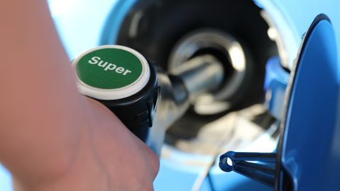 Foto de una persona poniendo gasolina super en una estación de servicio