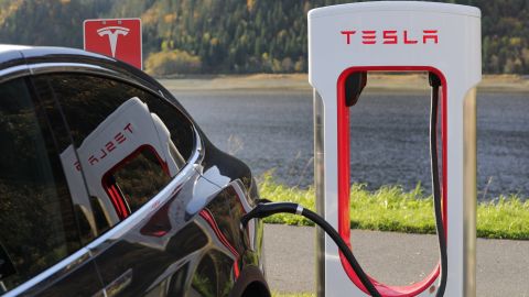 Foto de un auto Tesla siendo cargado en una estación de carga de la marca