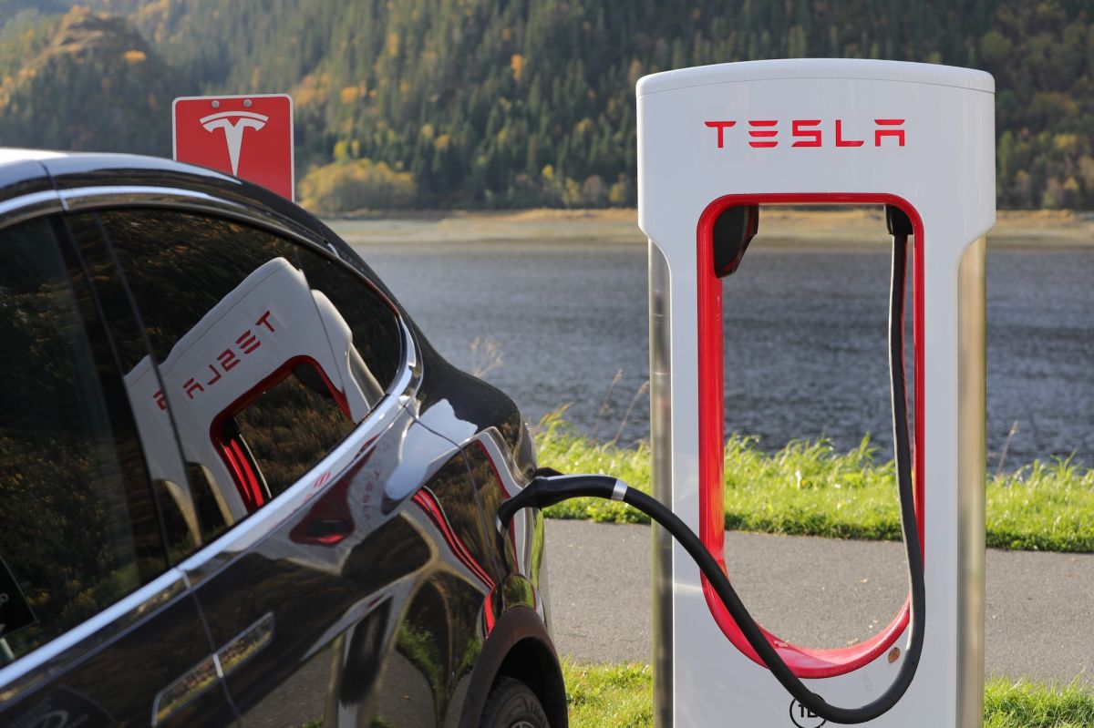 Foto de un auto Tesla siendo cargado en una estación de carga de la marca