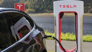 Foto de un auto Tesla siendo cargado en una estación de carga de la marca