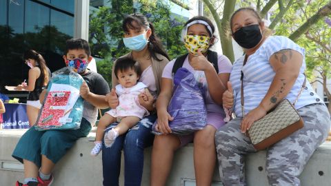 Los hijos de Verónica Jiménes (d), de 14, 11 y 6 años, recibieron ayer sus mochilas con útiles. / fotos: Jorge Luis Macías.