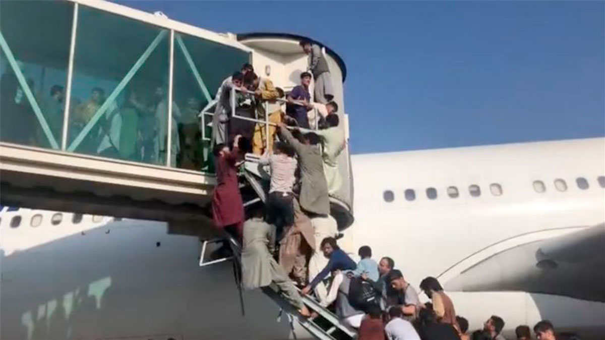 La gente intenta montarse a los aviones en busca de escapar.