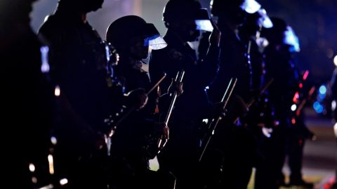 La policía se prepara a contener a un grupo de manifestantes.