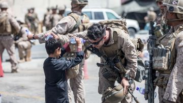 Un infante de marina y un niño se rocían agua durante la evacuación de 
Afganistán.