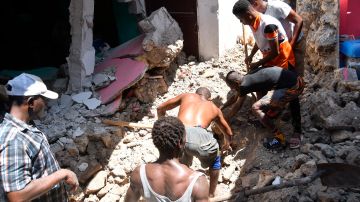 Personas buscan sobrevivientes bajo los escombros, después del terremoto en Haití.