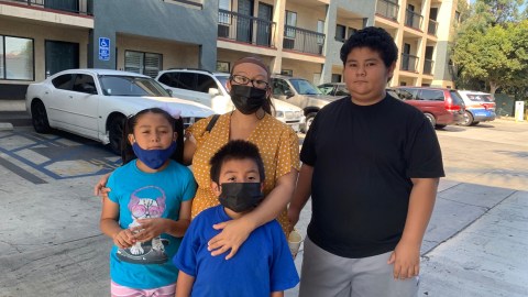 Zoila Córdova Islas con tres de sus 5 hijos, recibe ayuda de los estudiantes de Lynwood High School. (Araceli Martínez/La Opinión)