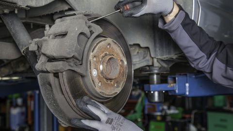 Foto de un auto en un taller mecánico mostrando el disco de freno