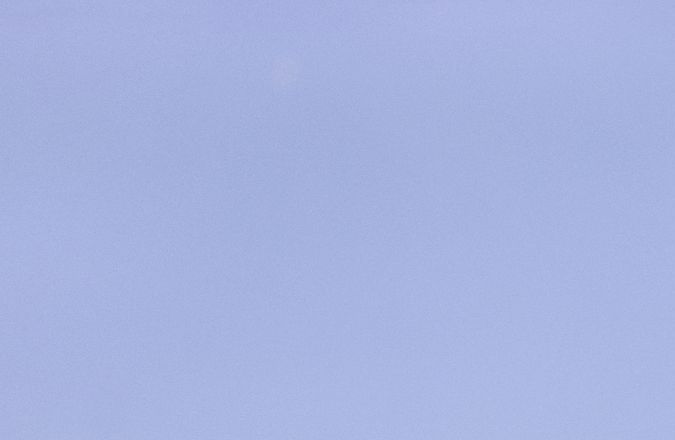 Foto del logo de General Motors en la pantalla de un teléfono con el edificio al fondo