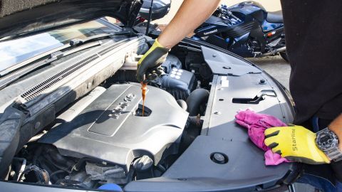 Foto de una persona revisando el aceite de motor de un auto