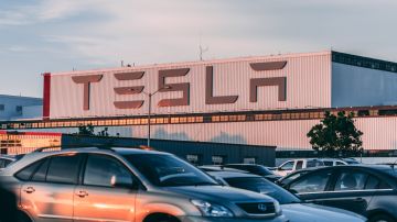 Foto de una fábrica de Tesla con vehículos de otras marcas estacionadas en frente