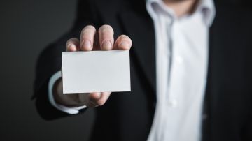 Foto de un hombre mostrando una tarjeta de identificación en blanco