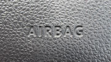 Foto del tablero de un auto mostrando la palabra Airbag