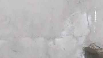 TOPSHOT - A man gestures while seated beside a Skid Row painting on a sidewalk in downtown Los Angeles on May 30, 2019. - The city of Los Angeles on May 29 agreed to allow homeless people on Skid Row to keep their property and not have it seized, providing the items are not bulky or hazardous. (Photo by Frederic J. BROWN / AFP) (Photo credit should read FREDERIC J. BROWN/AFP via Getty Images)