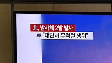 Un hombre mira una transmisión de prueba de misiles en Corea del Norte.