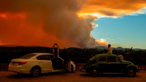 TOPSHOT - People watch the Walbridge fire, part of the larger LNU Lightning Complex fire, from a vineyard in Healdsburg, California on August 20, 2020. - A series of massive fires in northern and central California forced more evacuations as they quickly spread August 20, darkening the skies and dangerously affecting air quality. (Photo by JOSH EDELSON / AFP) (Photo by JOSH EDELSON/AFP via Getty Images)