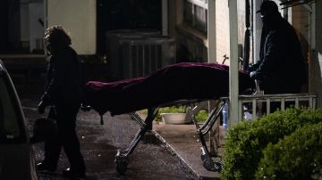TOPSHOT - People with the medical examiner's office wheel out a body on a stretcher from a massage parlor where three people were shot and killed on March 16, 2021, in Atlanta, Georgia. - Eight people were killed in shootings at three different spas in the US state of Georgia on March 16, police and local media reported. It is "extremely likely" that the same suspect was involved in all three deadly shootings at spas in the US state of Georgia, police told AFP Tuesday. The suspect, named as 21-year-old Robert Aaron Long, is in police custody in the violence that reportedly killed eight people. (Photo by Elijah Nouvelage / AFP) (Photo by ELIJAH NOUVELAGE/AFP via Getty Images)