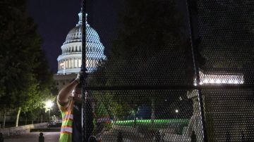 Trabajadores instalan vallas de seguridad en el Capitolio antes del mitin del fin de semana.