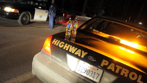 California Highway Patrol officers confer at a roadblock on Highway 38 near Angeles Oaks during a standoff with fugitive ex-cop Christopher Dorner, near San Bernardino, California on February 12, 2013. Nobody has yet been found in a burnt-out US mountain cabin where Dorner was believed to have barricaded himself after a six-day manhunt, a police spokesman said. Media reports that a body had been found in the cabin near Big Bear, east of Los Angeles, and identified as Dorner's were false, said Los Angeles Police Department (LAPD) spokesman Andrew Smith. AFP PHOTO /JOE KLAMAR (Photo credit should read JOE KLAMAR/AFP via Getty Images)