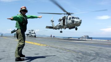 AT SEA - JANUARY 11: In this handout image provided by the U.S. Navy, a Landing Signals Enlisted man directs an HH-60H Seahawk, assigned to the "Golden Falcons" of Helicopter Anti-Submarine Squadron Two (HS-2), to a safe landing on the flight deck aboard USS Abraham Lincoln (CVN 72) January 11, 2005 while at sea on the Indian Ocean. Helicopters assigned to Carrier Air Wing Two (CVW-2) and Sailors from USS Abraham Lincoln (CVN 72) are supporting Operation Unified Assistance, the humanitarian operation effort in the wake of the tsunami which struck Southeast Asia. The Abraham Lincoln Carrier Strike Group is currently operating in the Indian Ocean off the waters of Indonesia and Thailand. (Photo by Tyler J. Clements/U.S. Navy via Getty Images)