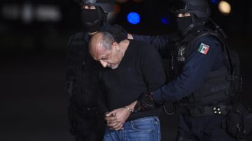 Mexican federal police escort Servando Gomez (C), aka "La Tuta" upon his arrival at the airport of Mexico City on February 27, 2015. Mexican police captured Knights Templar drug cartel's leader Servando Gomez, aka "La Tuta" on Friday in Morelia, Michoacan, taking down one of the country's most wanted fugitives whose gang tormented the western state of Michoacan. AFP PHOTO/ALFREDO ESTRELLA        (Photo credit should read ALFREDO ESTRELLA/AFP via Getty Images)