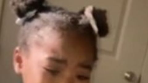 La niña llora con pasaporte de su madre en mano.